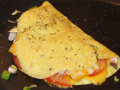 Omelette with cheese and slices of tomato.