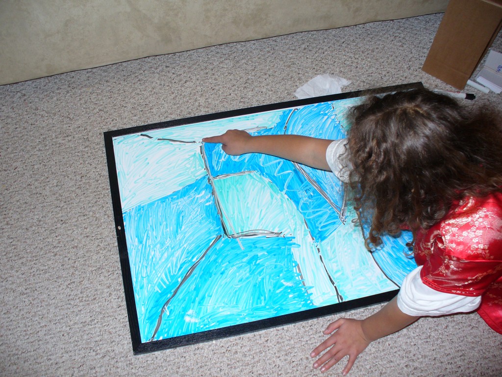 Lila pointing out the "E" in her whiteboard art