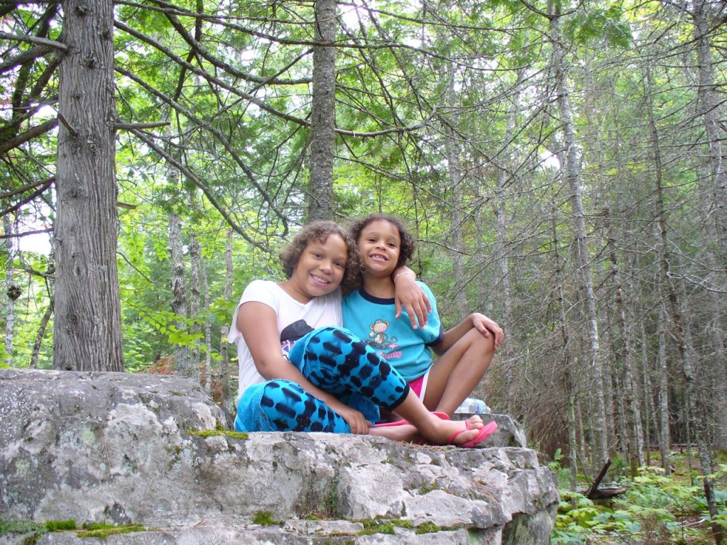 Lila and Eva posing on a boulder.