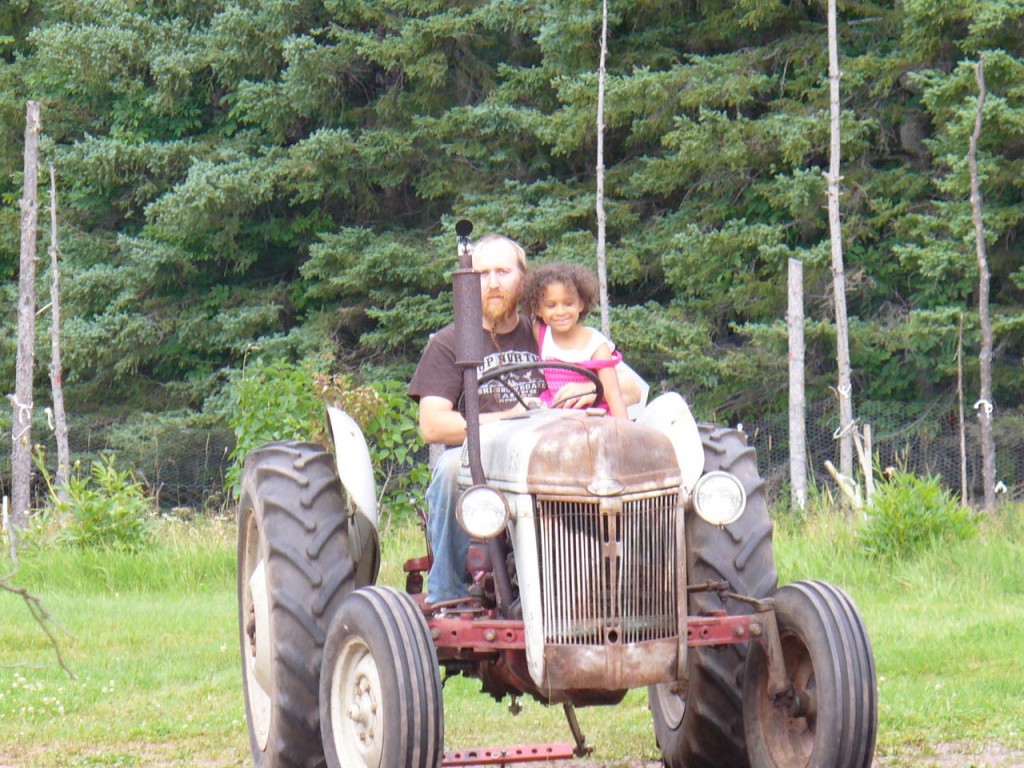 Eva getting a tractor ride from uncle A.J.