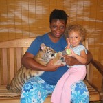 Chey and Lila feeding a baby tiger.