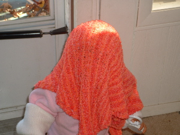 Eva walking under a knit blanket