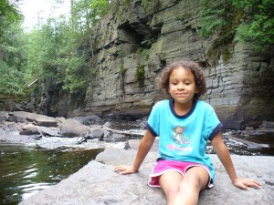 Eva sitting on rock in river