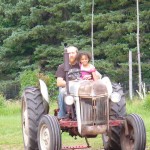 Eva getting a tractor ride from uncle A.J.