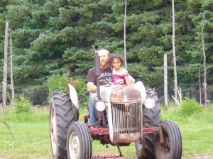 Eva getting a tractor ride from uncle A.J.